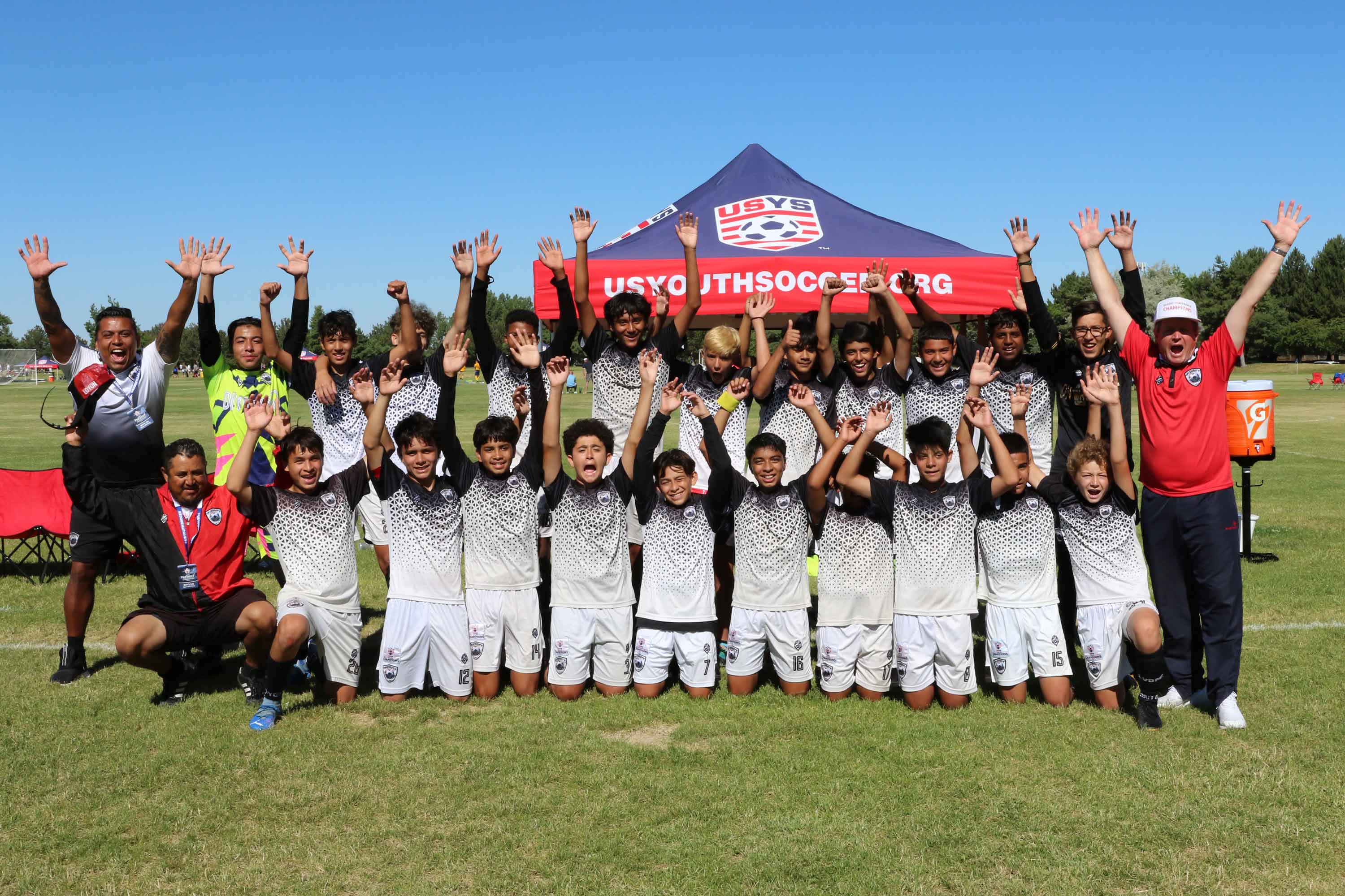 kids soccer team posing for a photo after winning a match