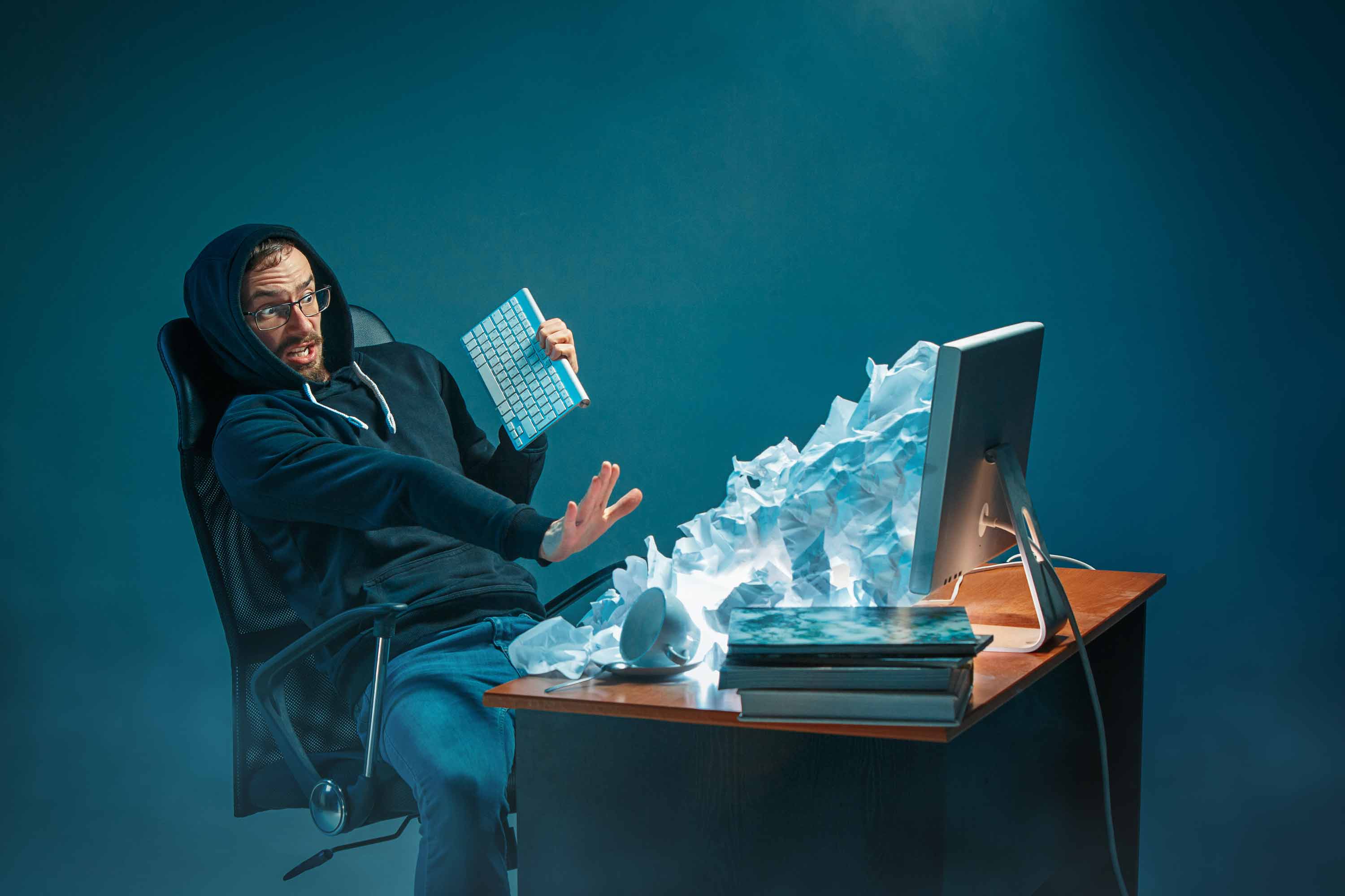 young stressed handsome businessman working desk modern office shouting laptop screen being angry about spam