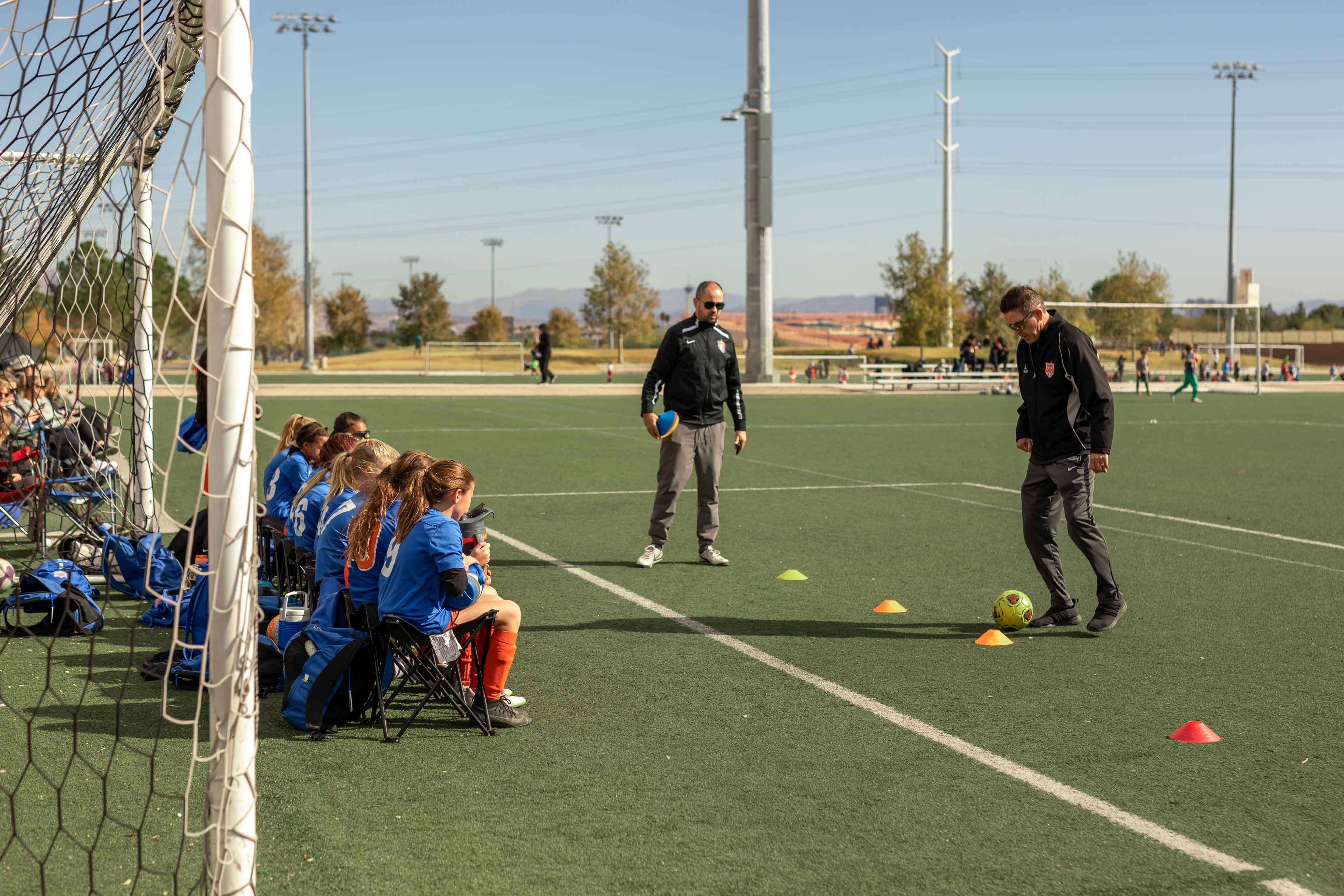 coach showing his team how to dribble the ball