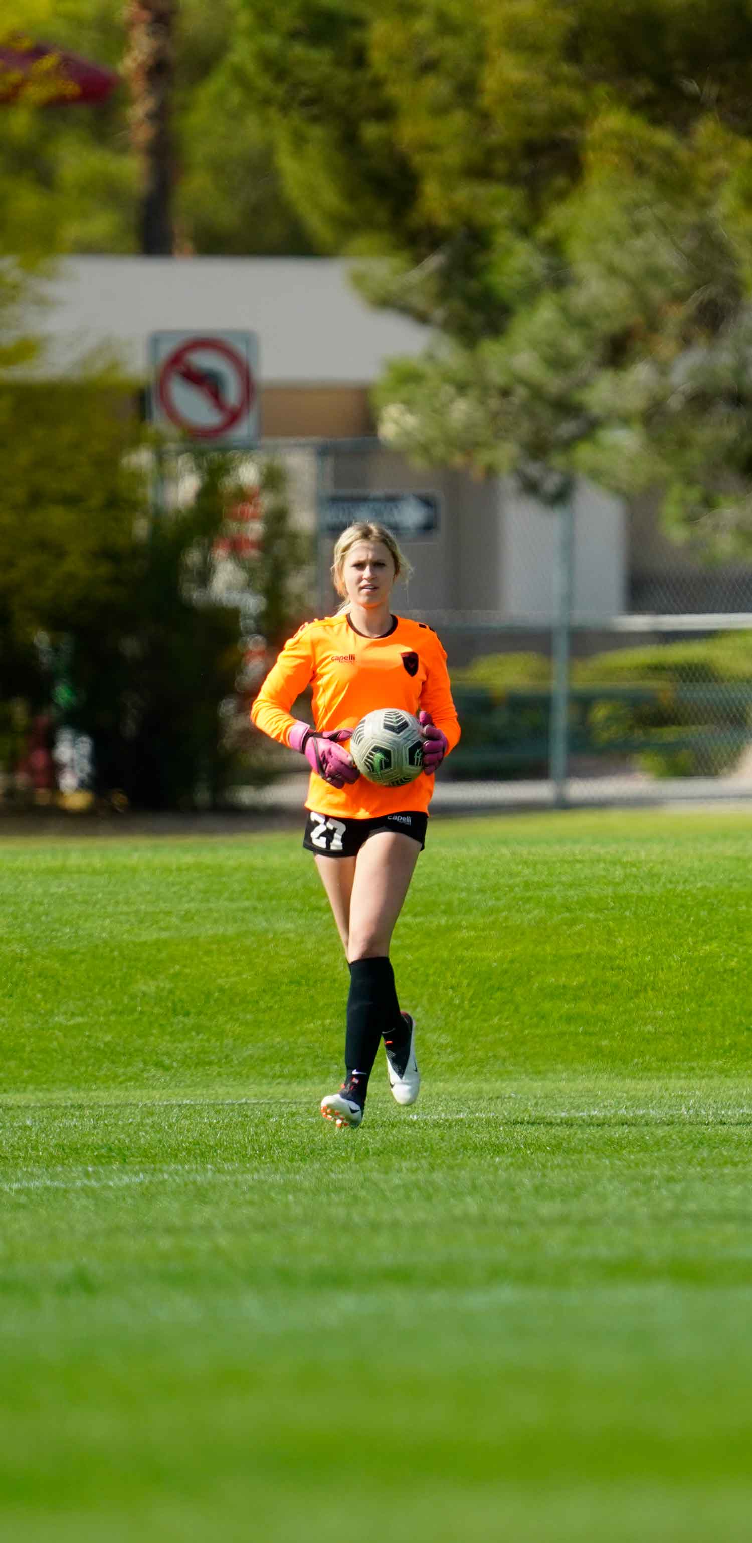 woman goalie holding the ball ready to start a play