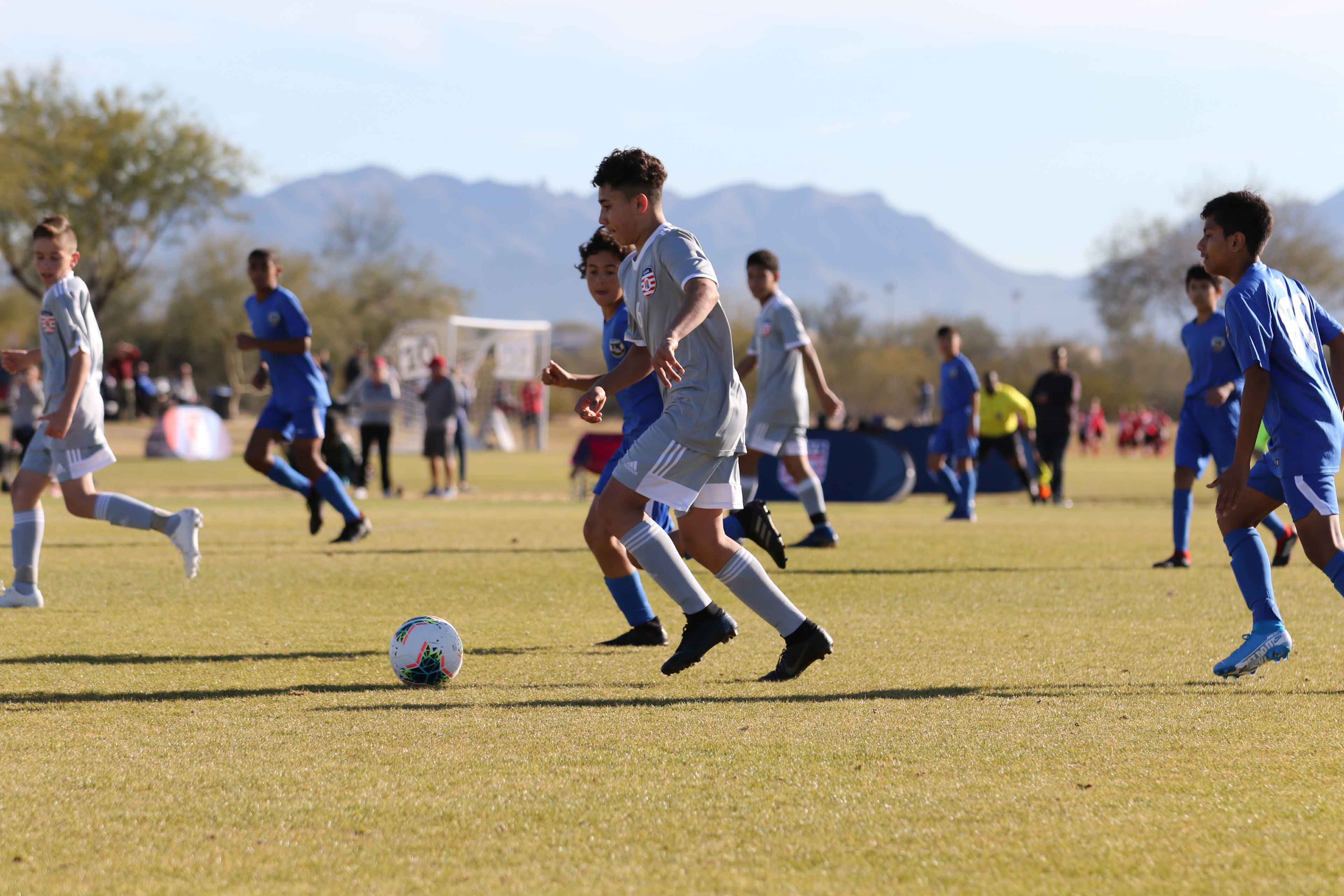 kid driblilng the ball on the soccer field advaning to go and make a goal 1