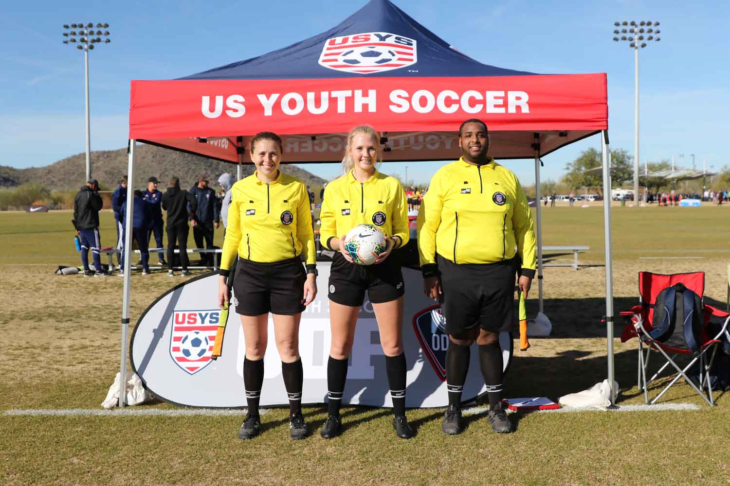 referees of a match posing for a photo two girls and one guy